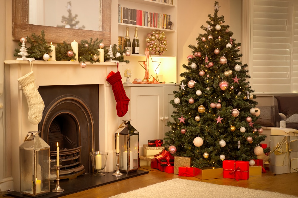 Salotto decorato per Natale con albero addobbato, regali, camino con calze e candele